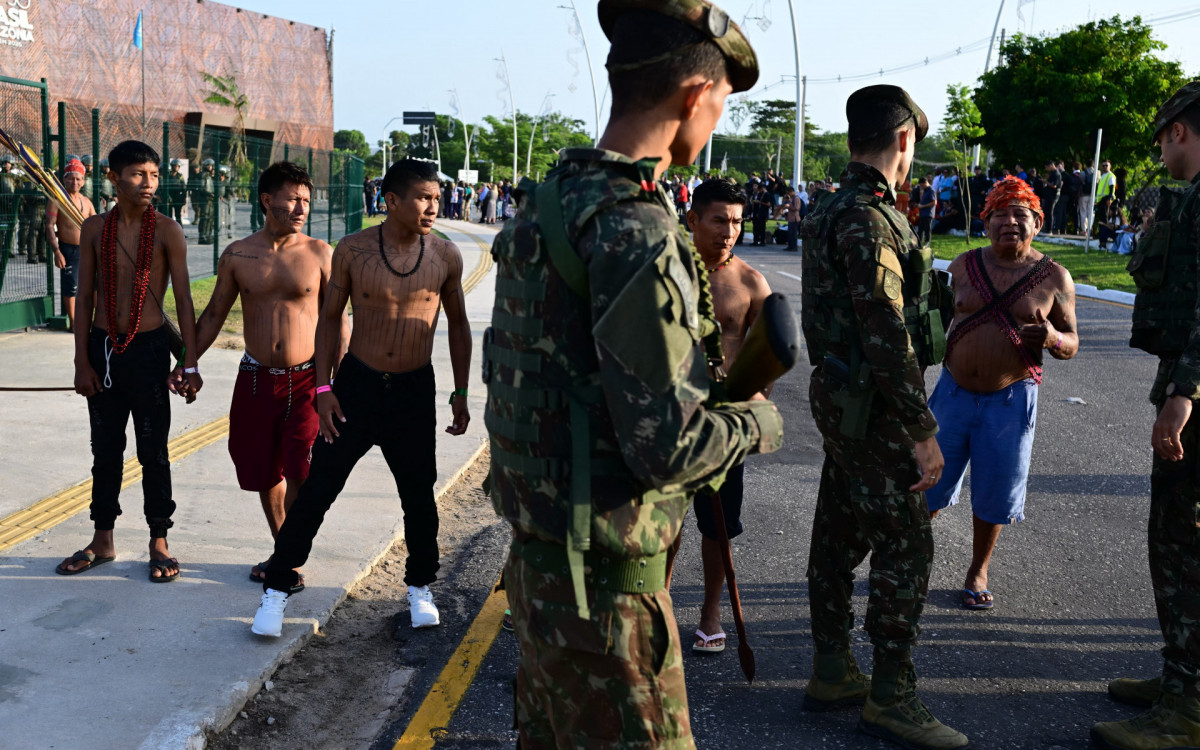 Membros do movimento indígena Munduruku Ipereg Ayu fazem protesto do lado de fora do local da COP30 em Belém - AFP