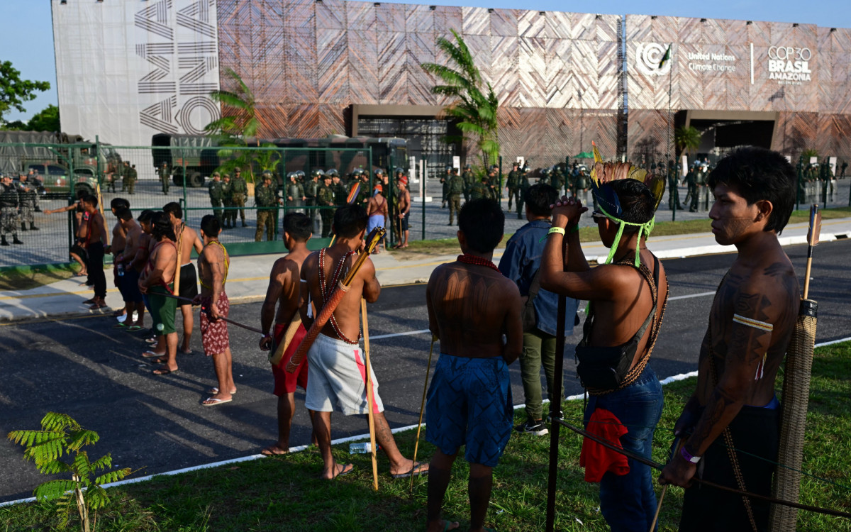 Membros do movimento indígena Munduruku Ipereg Ayu fazem protesto do lado de fora do local da COP30 em Belém - AFP