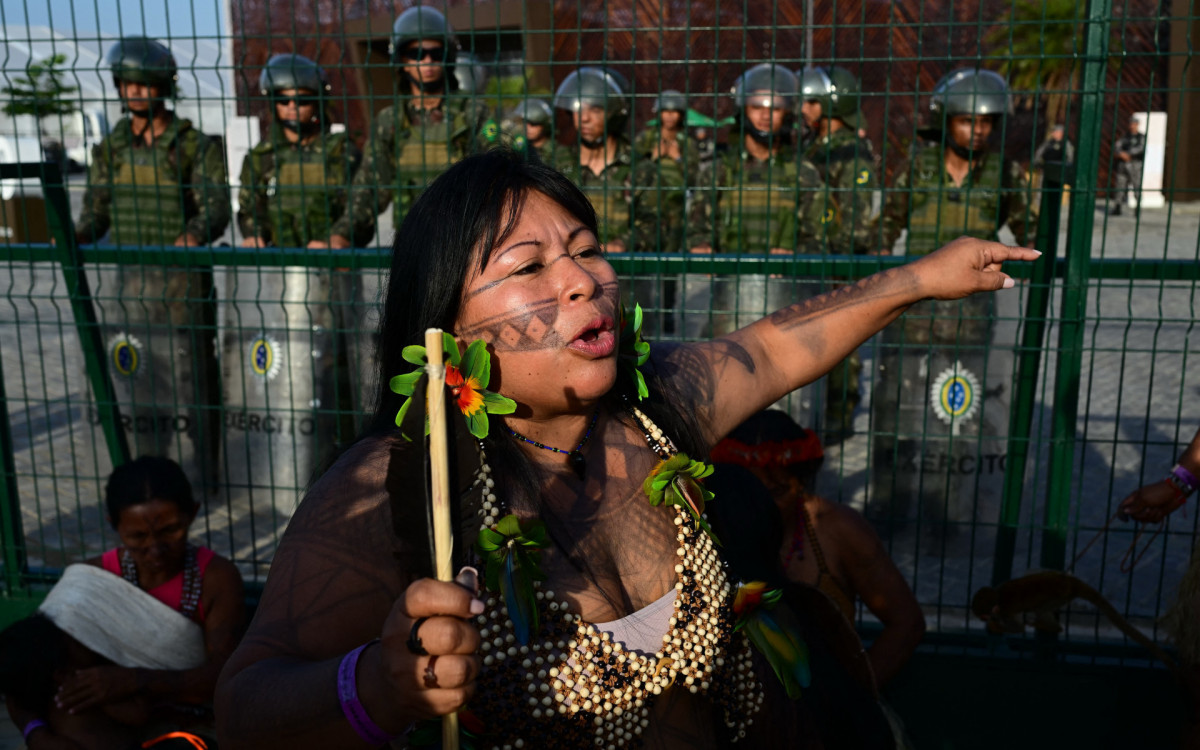 Membros do movimento indígena Munduruku Ipereg Ayu fazem protesto do lado de fora do local da COP30 em Belém - AFP