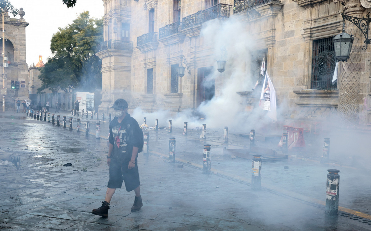 Manifestante se afasta do gás lacrimogêneo durante confrontos em um protesto contra o governo do México - AFP