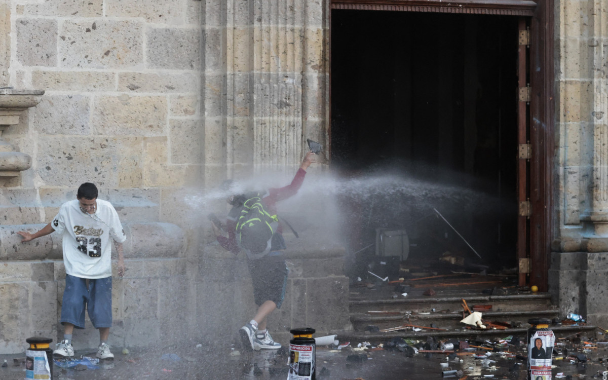 anifestante é atingido por jatos de água do Palácio do Governo - AFP