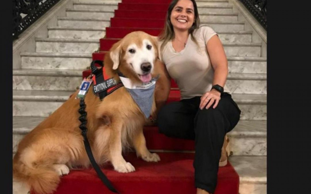 Daniele Cristo sorri na companhia de Prince, seu primeiro cão de suporte emocional 