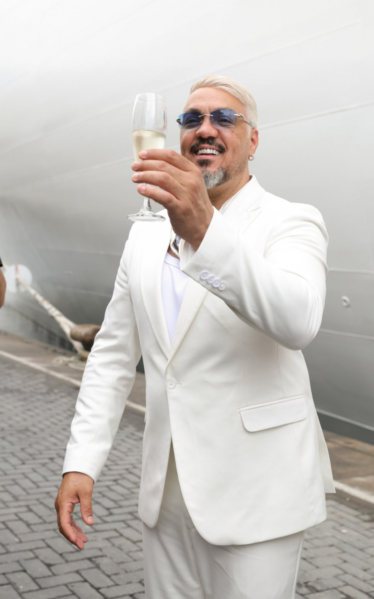 Belo chama atenção ao surgir com novo visual no embarque do cruzeiro