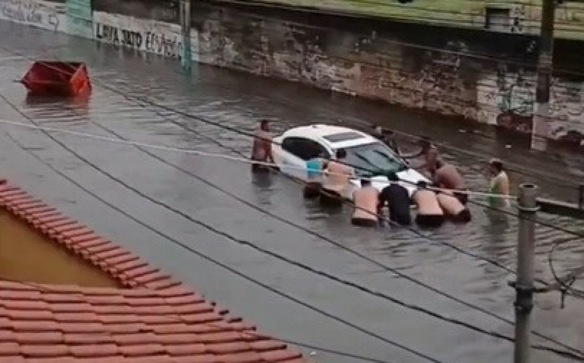 Carro ficou parcialmente submerso na Rua Uranos, em Bonsucesso