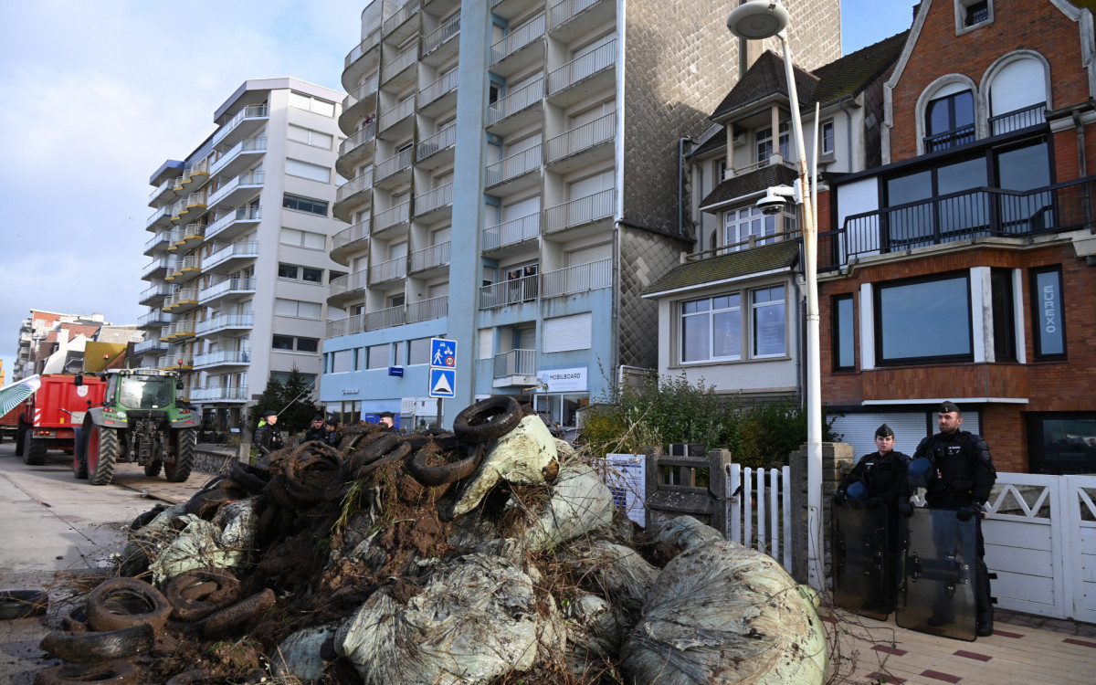 Manifestantes jogaram vários sacos de esterco, pneus, repolhos e galhos  - AFP
