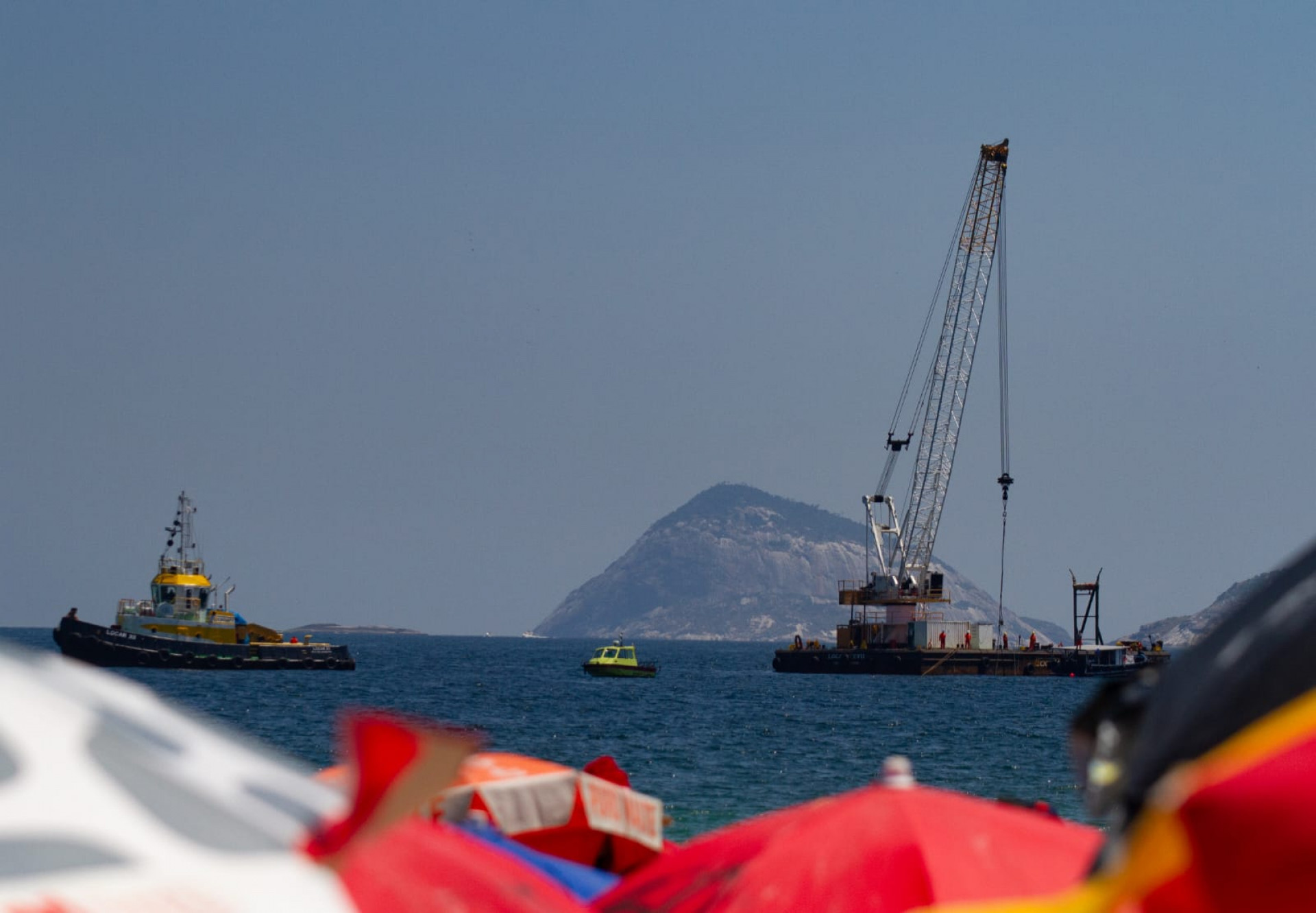 Balsa com guindaste trabalha para retirada de destroços do monomotor em Copacabana - Érica Martin / Agência O Dia