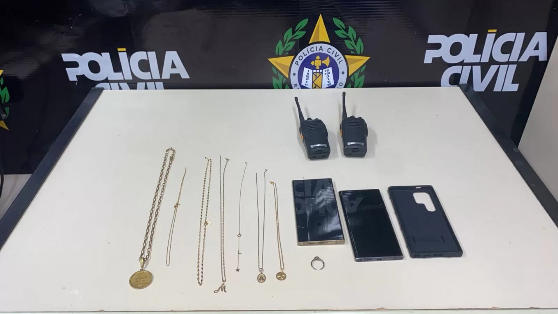 Cordões, um anel, rádios comunicadores e telefones celulares - Reprodução/PM