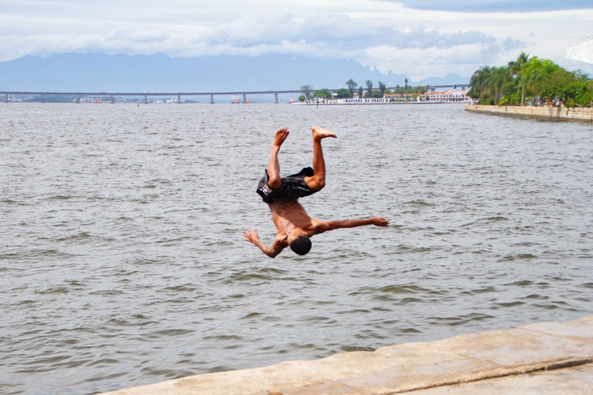 Jovens se banham na Baía de Guanabara em dia de temperatura amena no Rio - Érica Martin/Agência O Dia