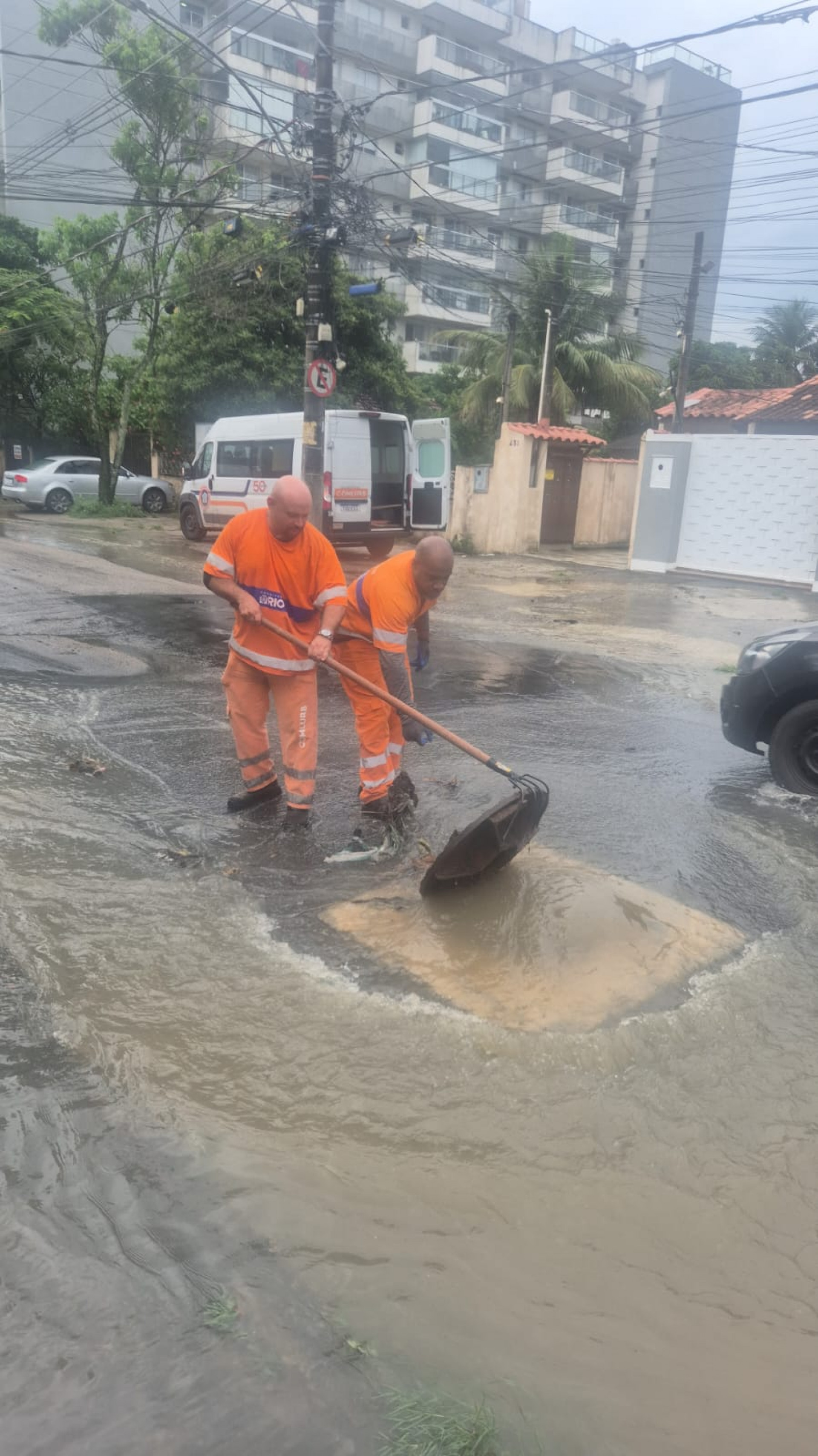 Trabalhadores da Comlurb tentam desobstruir uma galeria subterrânea na Rua Quatis, no bairro dos Bancários, Ilha do Governador