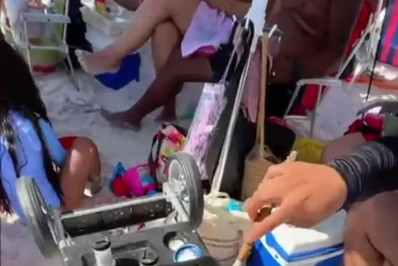 Turistas preparam linguiça acebolada na Praia do Forte, em Cabo Frio