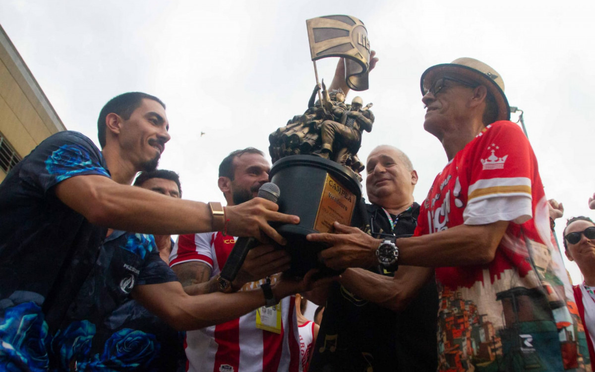 Mestre Ciça levanta o troféu conquistado pela Viradouro