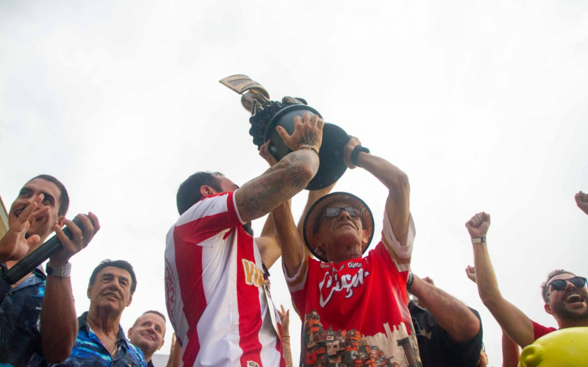 Mestre Ciça levanta o troféu conquistado pela Viradouro