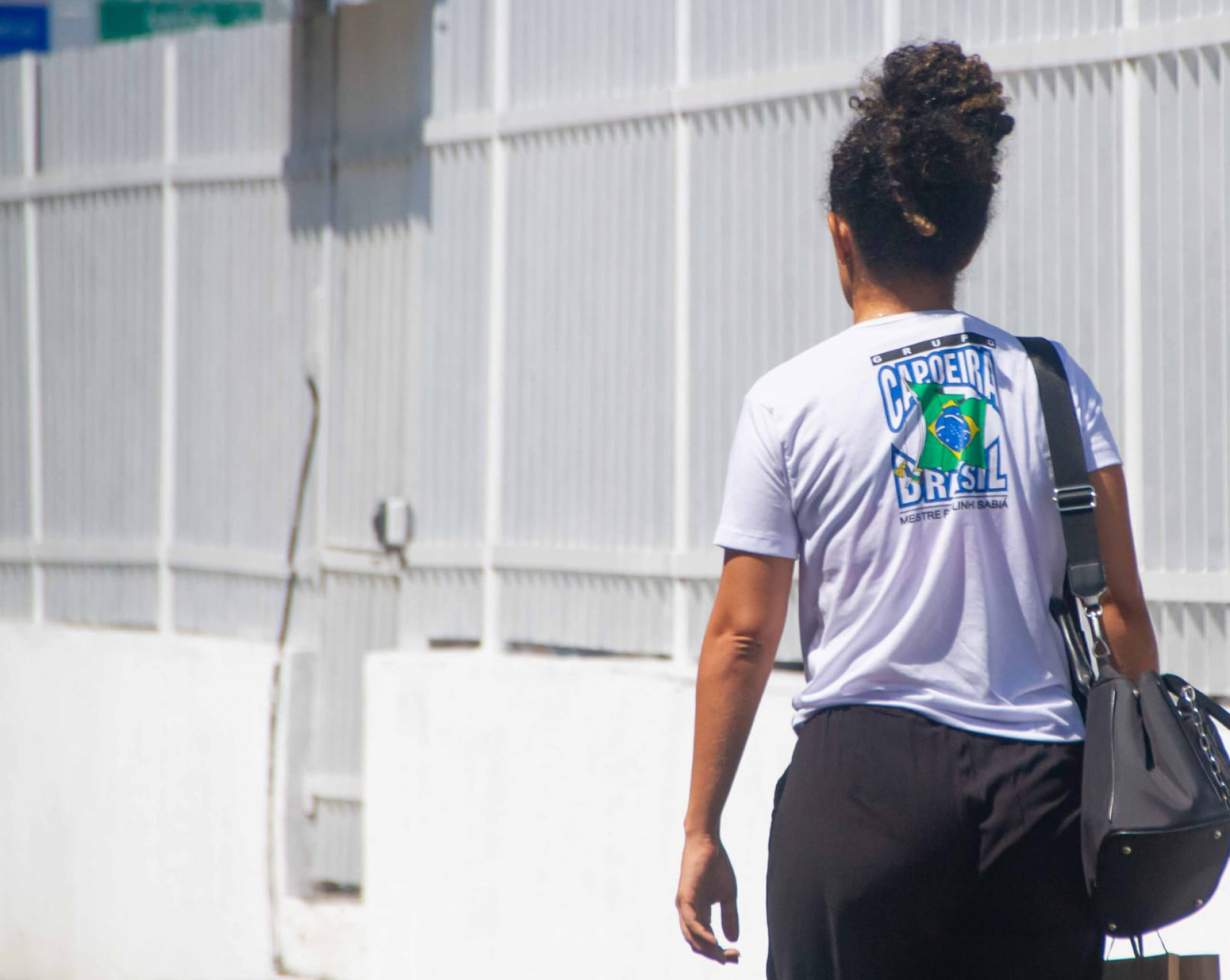 Simara, esposa de Paulinho, compareceu ao IML com a blusa da organização Capoeira Brasil, fundada pelo mestre - Érica Martin / Agência O Dia