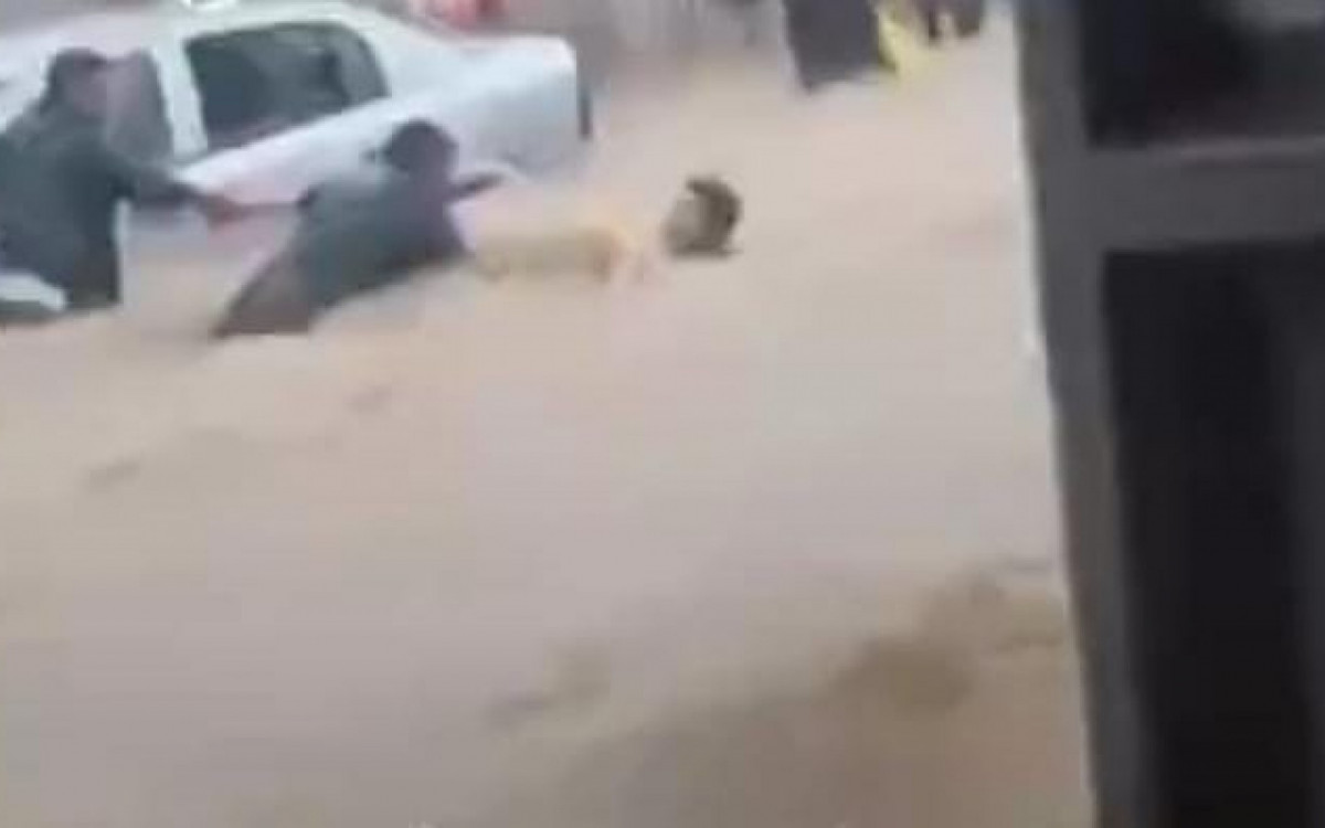 Corrente humana salva homem de ser levado pela enxurrada