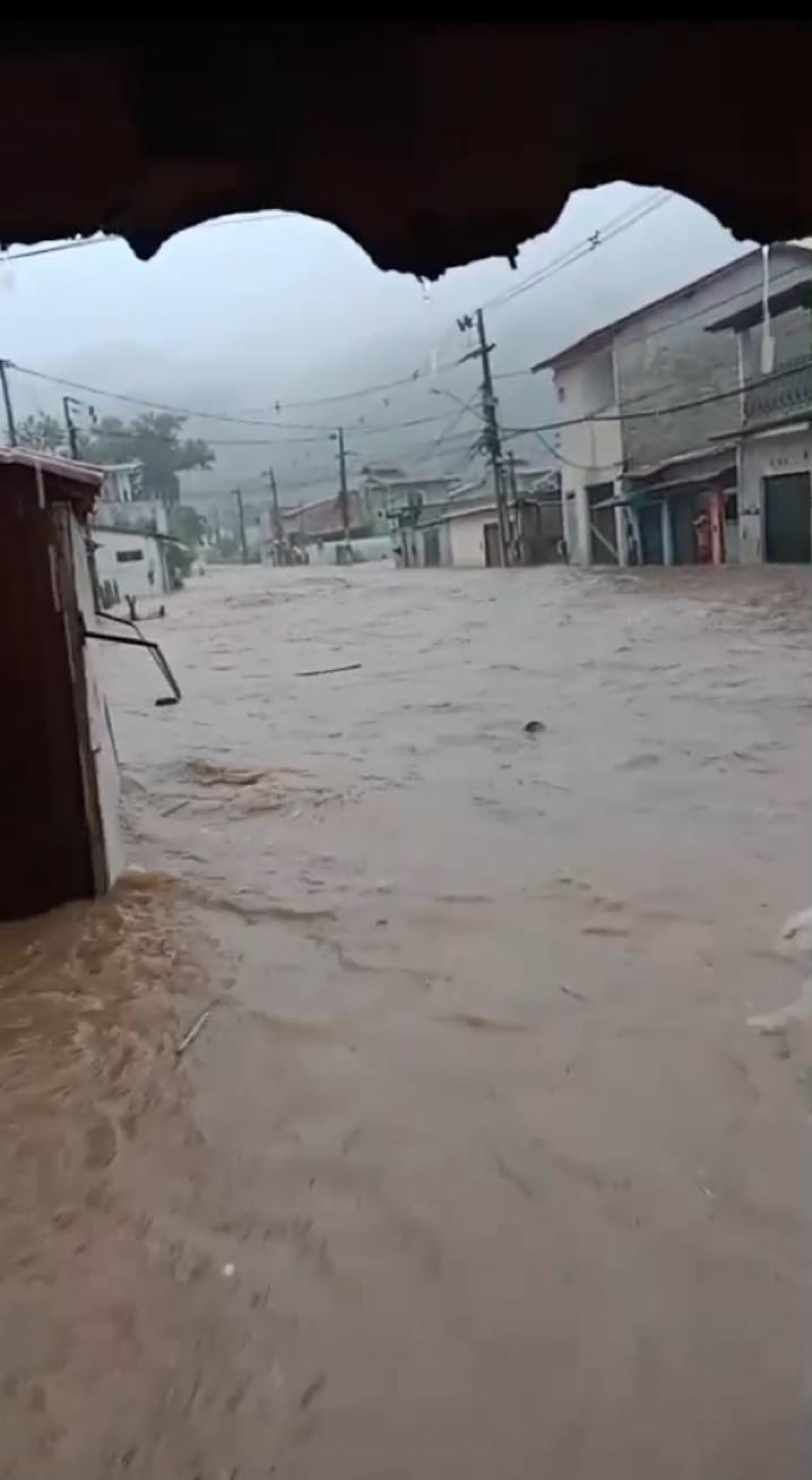 Passageiros buscam abrigo no ponto de &ocirc;nibus em Paraty que &eacute; tomado pela chuva - Divulga&ccedil;&atilde;o