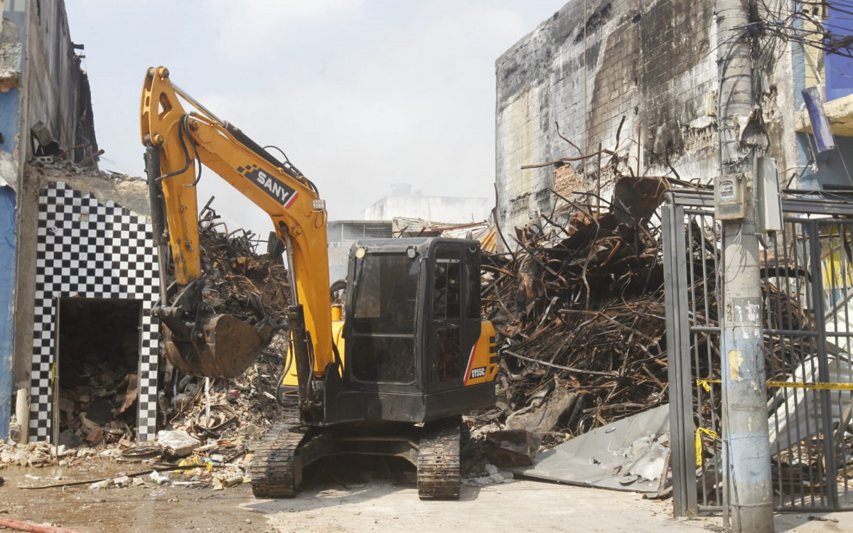 Escavadeira utilizada para auxiliar no combate aos pequenos focos de incêndio