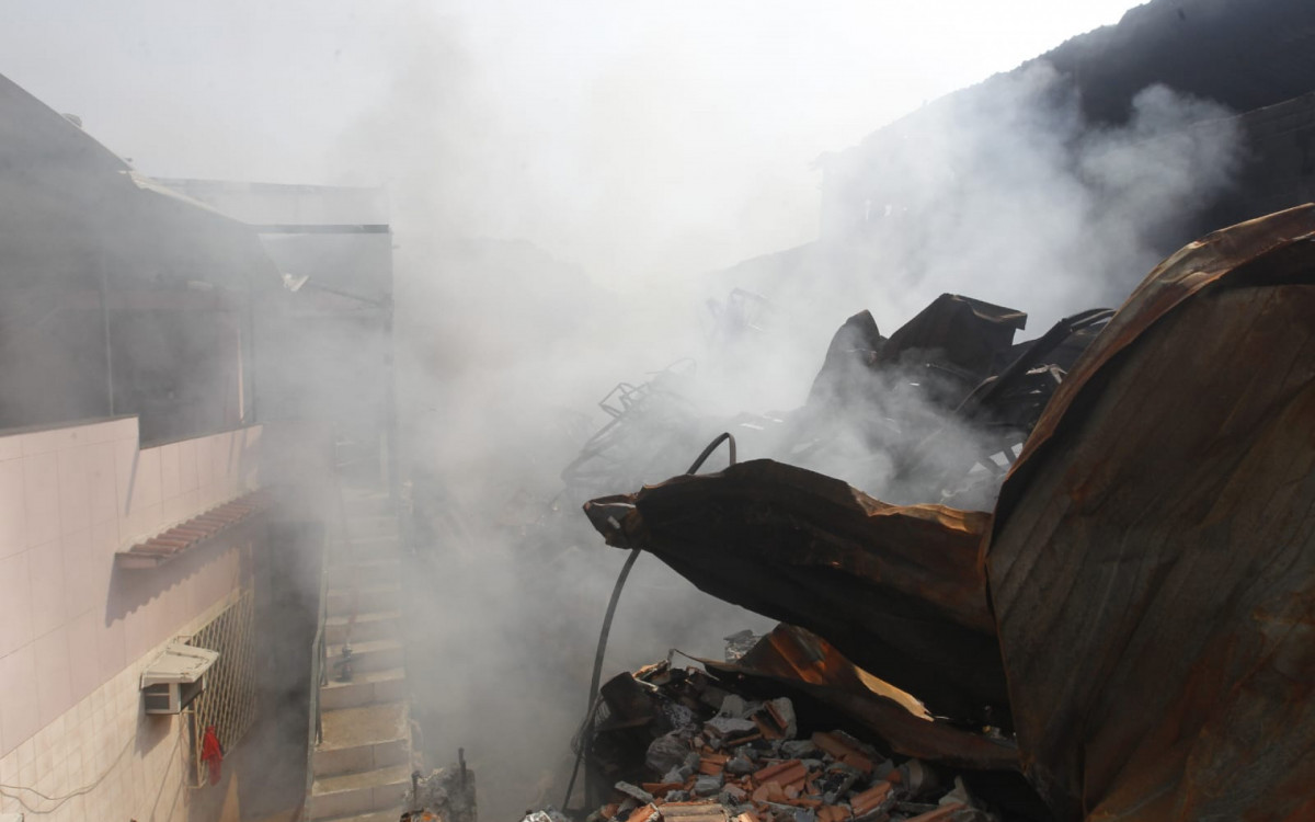 Fogo segue produzindo fumaça nos escombros da loja Motocriss, em Ramos