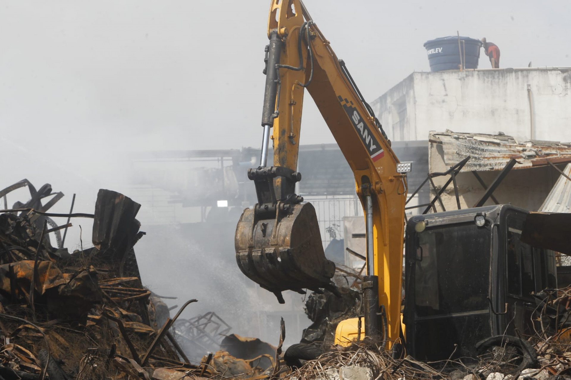 Escavadeira utilizada para auxiliar no combate aos pequenos focos de incêndio - Reginaldo Pimenta / Agência O Dia