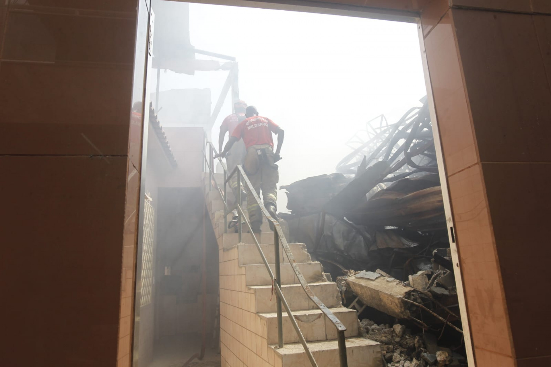 Bombeiros sobem na escada da casa do Jorge Augusto, que teve a parede destruída - Reginaldo Pimenta / Agência O Dia