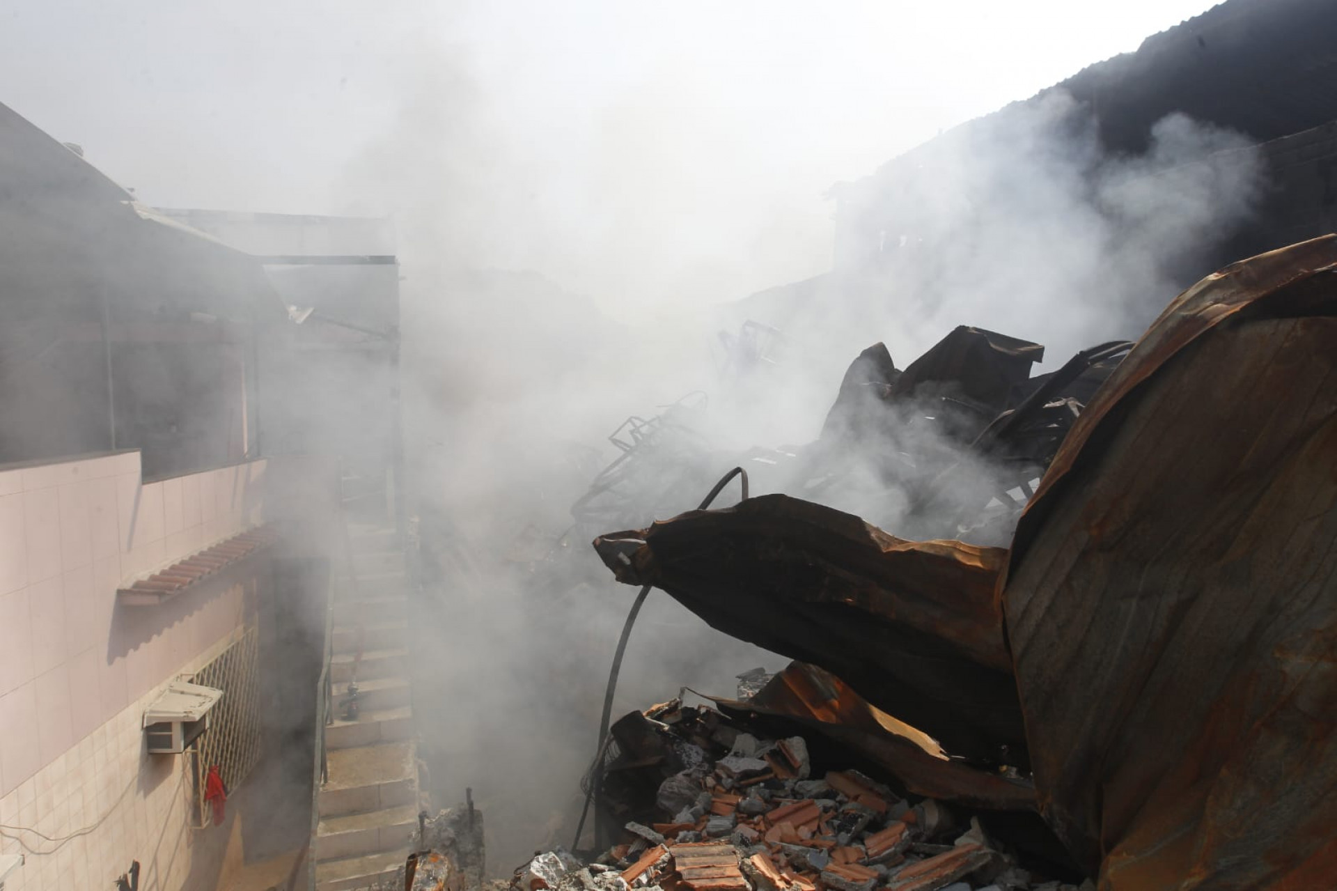 Fogo segue produzindo fumaça nos escombros da loja Motocriss, em Ramos - Reginaldo Pimenta / Agência O Dia