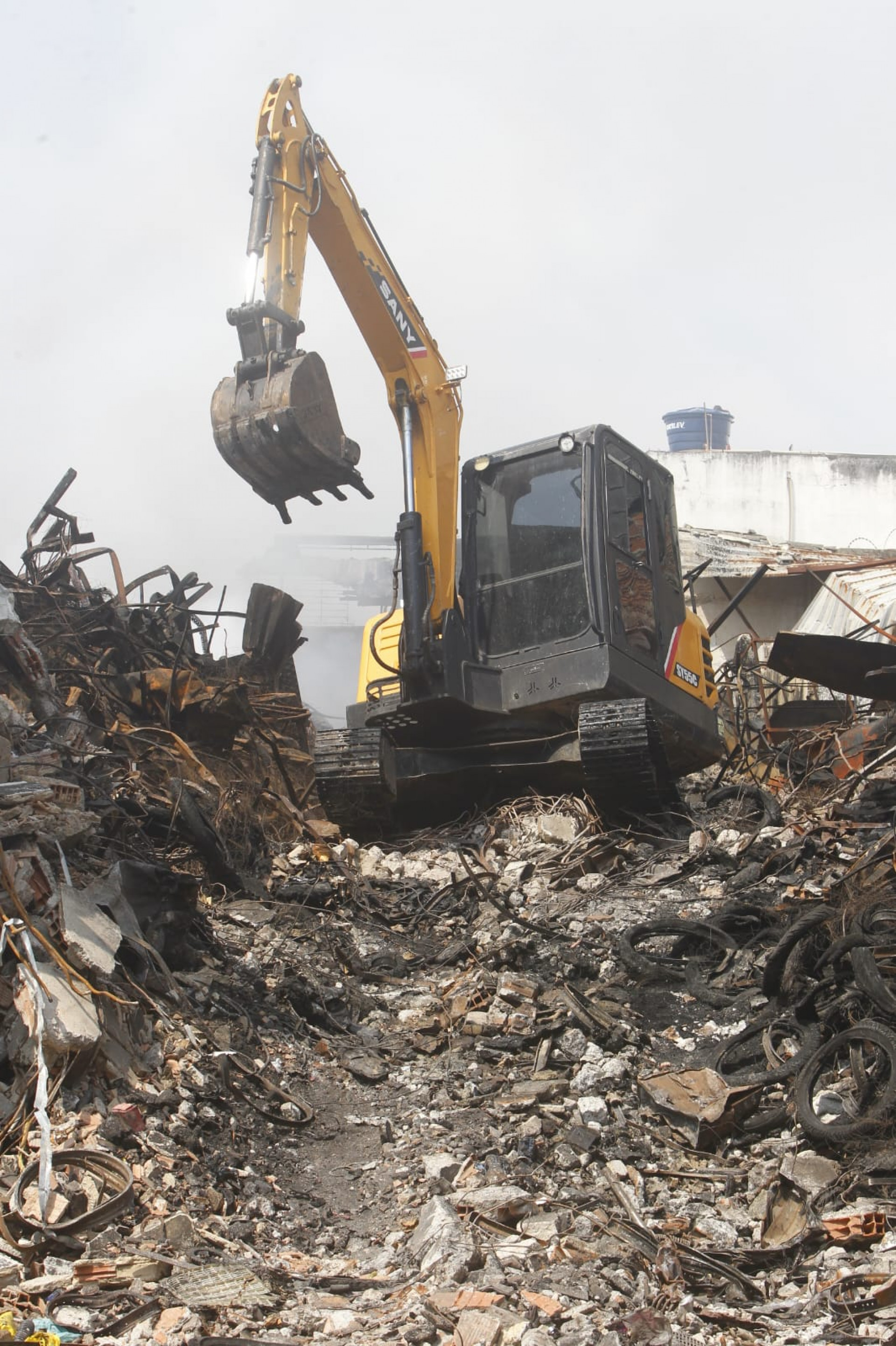 Escavadeira utilizada para auxiliar no combate aos pequenos focos de incêndio - Reginaldo Pimenta / Agência O Dia