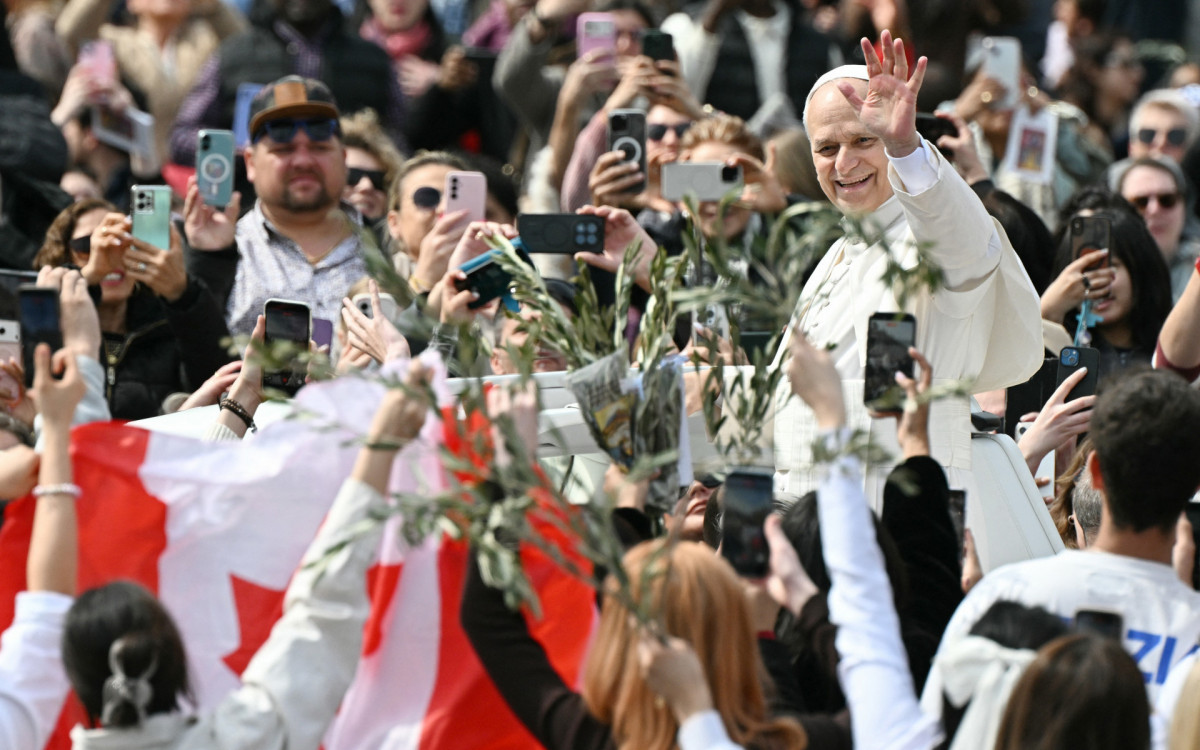 Papa Leão XIV saúda a multidão ao sair da Praça de São Pedro - AFP