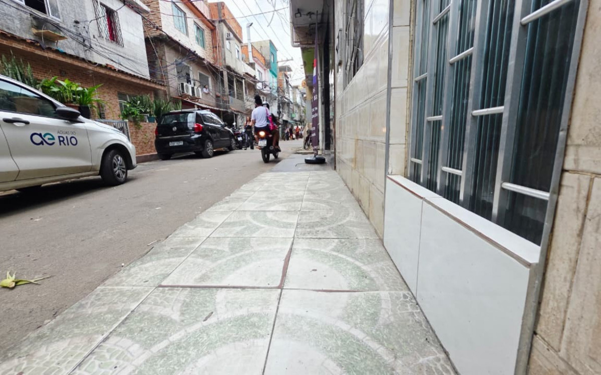 O \'degrauzinho do valão\' é a arquitetura da resistência na Maré, uma barreira de concreto essencial que protege o lar e a dignidade das famílias contra a invasão do esgoto e das enchentes