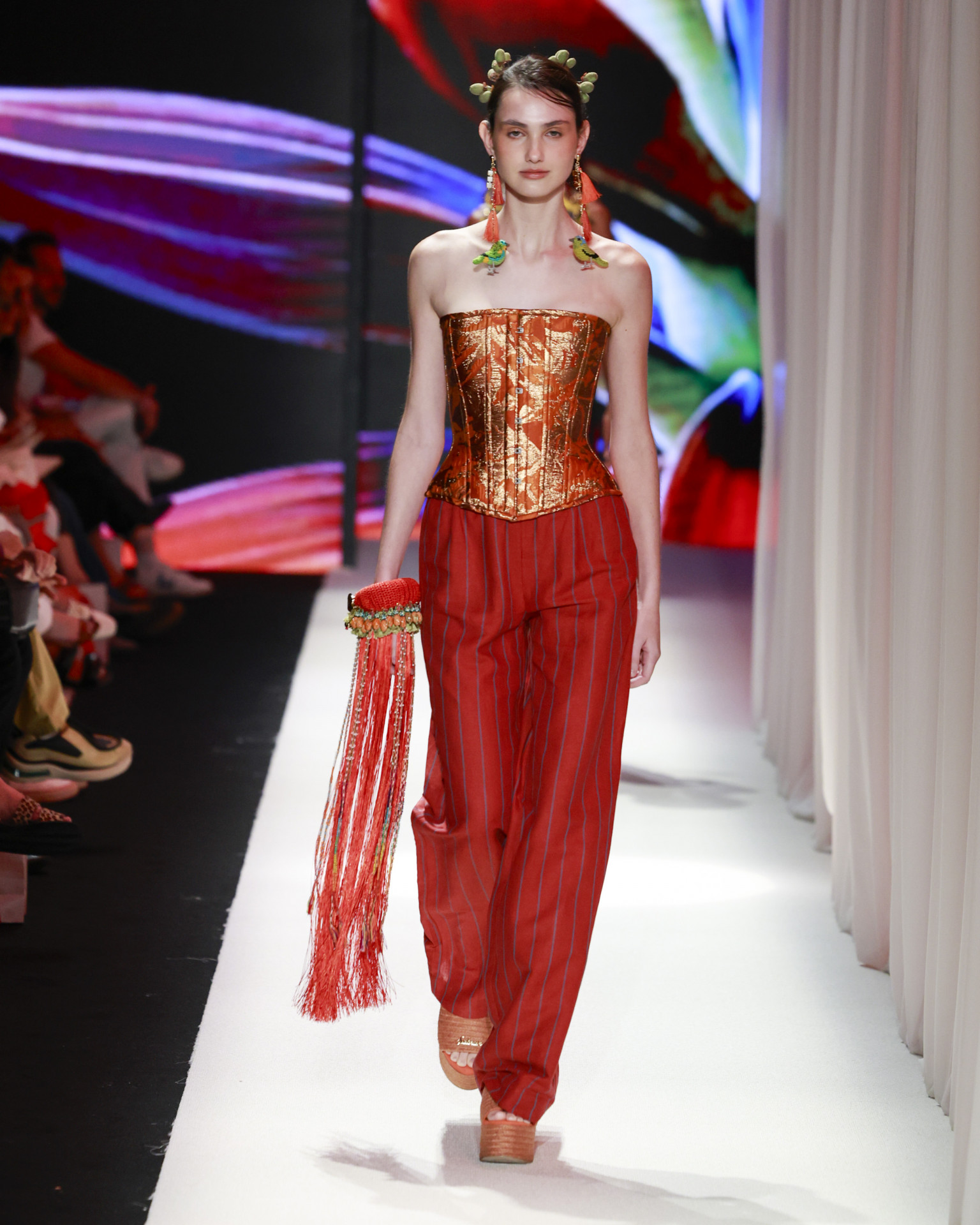 O corset metalizado encontra a alfaiataria descontraída em uma produção de forte apelo visual e espírito tropical sofisticado