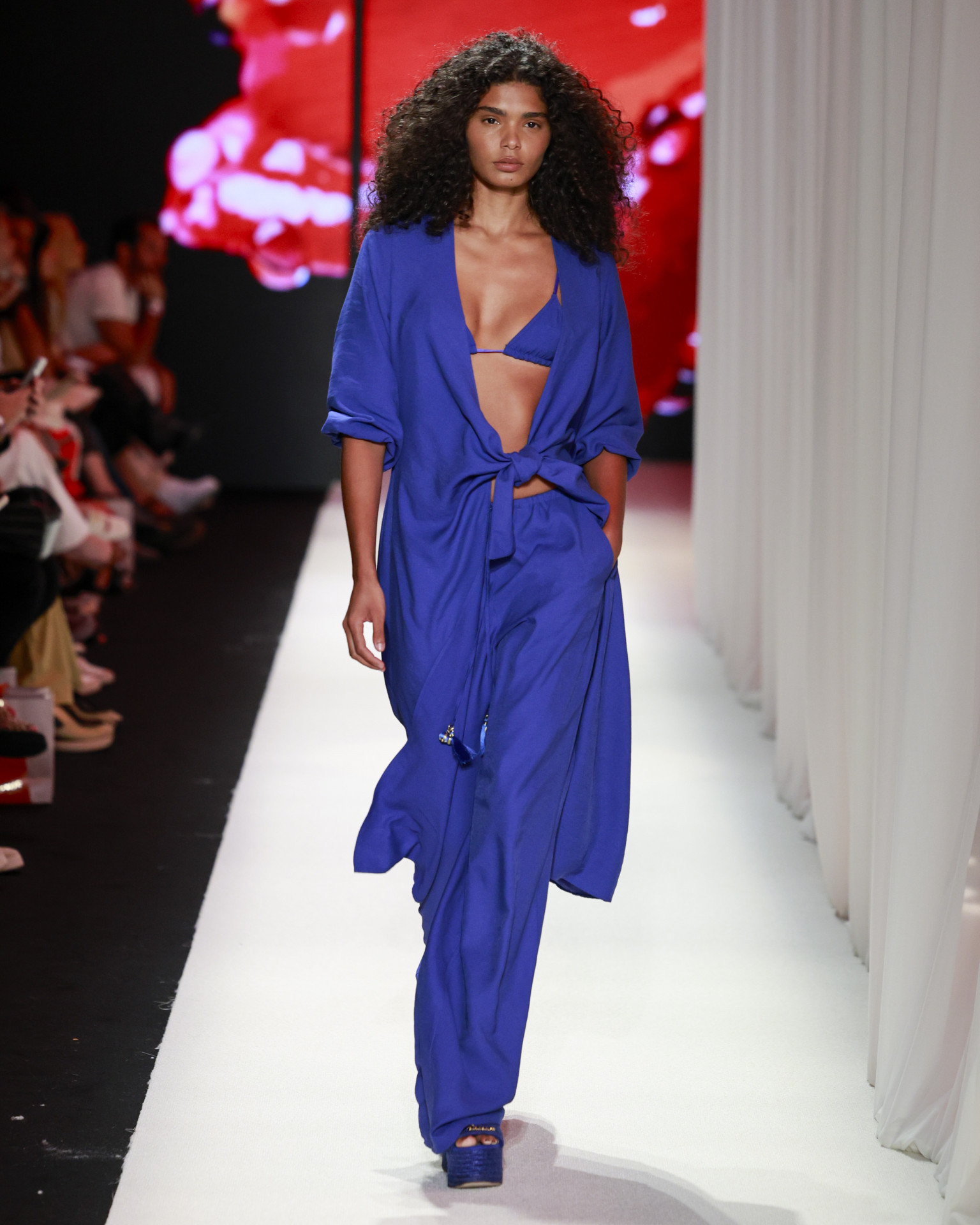 Em azul profundo, a composição de linhas fluidas reforça a elegância effortless que atravessa o universo da Salinas