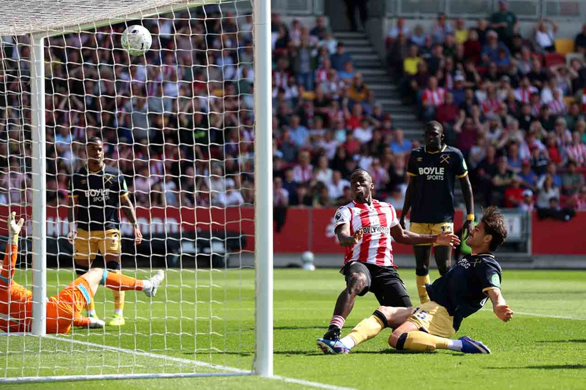BRENTFORD, ENGLAND - MAY 02: Michael Kayode of Brentford scores his team's first goal under pressure from Konstantinos Mavropanos of West Ham United during the Premier League match between Brentford and West Ham United at Gtech Community Stadium on May 02, 2026 in Brentford, England. (Photo by Julian Finney/Getty Images)