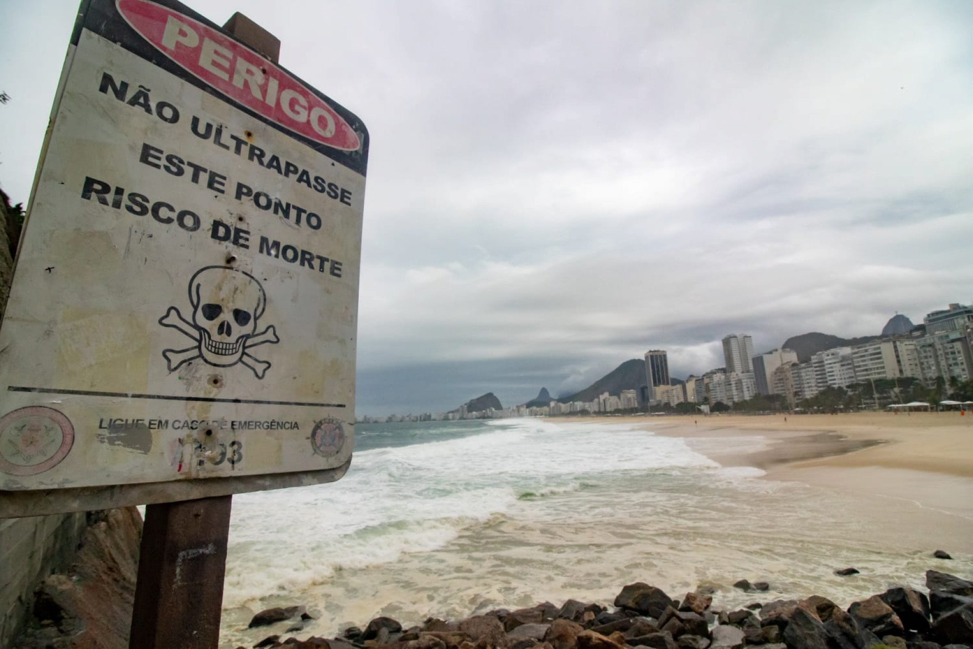 Placa de perigo próxima às pedras da Praia do Leme - Érica Martin / Agência O Dia
