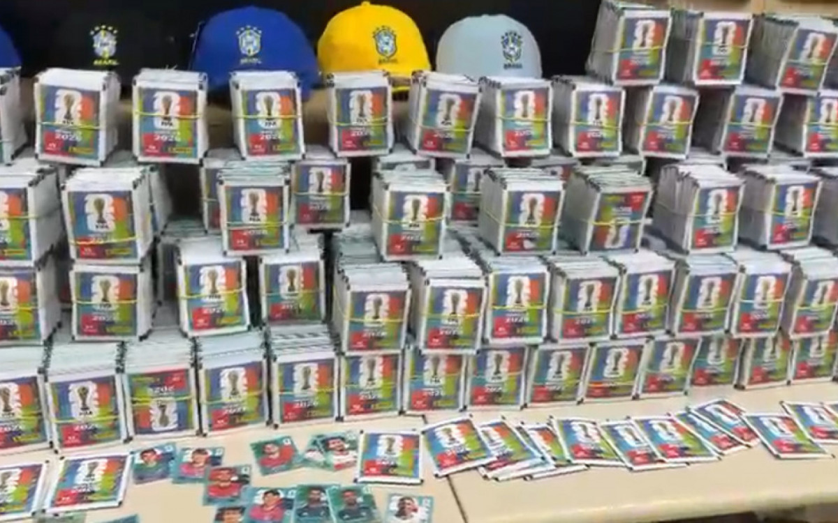 As figurinhas falsificadas imitavam o álbum oficial da Copa do Mundo de 2026. Já as camisas reproduziam de forma irregular o uniforme da Seleção Brasileira. - Reprodução/Polícia Civil 