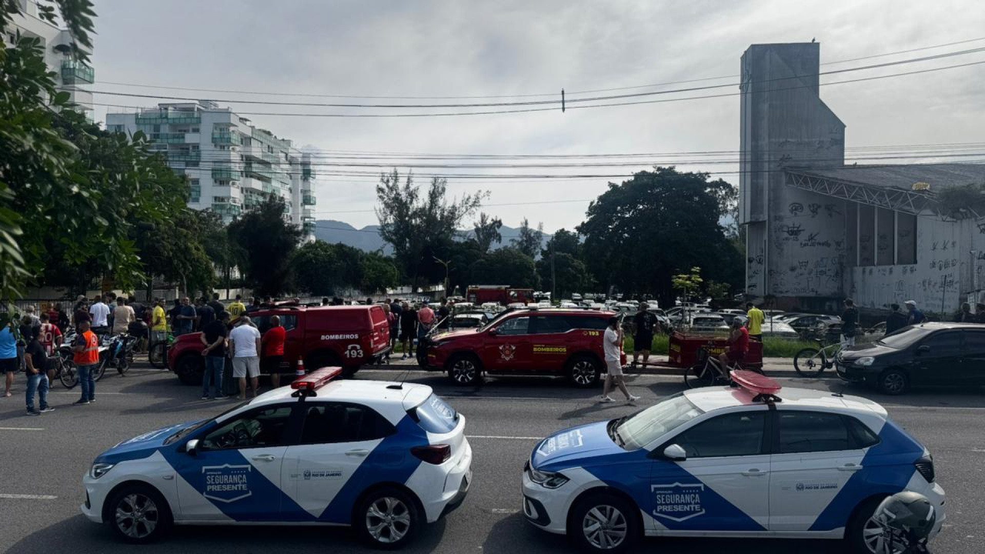 Diversas pessoas acompanham o trabalho do Corpo de Bombeiros no local da queda dos helic&oacute;pteros, no Recreio  - Gabriel Salotti / Ag&ecirc;ncia O Dia