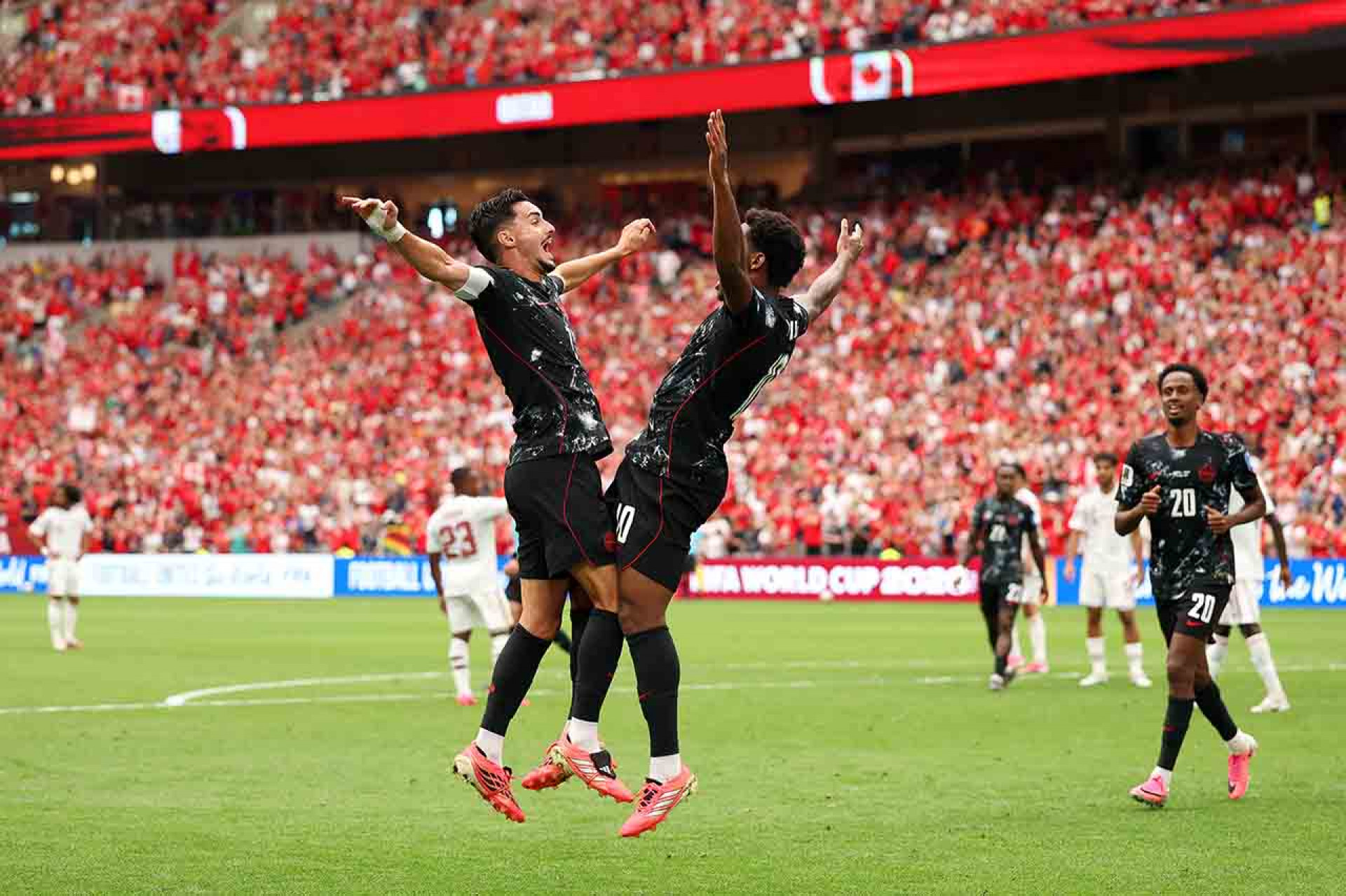 VANCOUVER, BRITISH COLUMBIA - JUNE 18: Jonathan David #10 of Canada celebrates with teammate Stephen Eustaquio #7 after scoring his team's third goal during the FIFA World Cup 2026 Group B match between Canada and Qatar at BC Place Vancouver on June 18, 2026 in Vancouver, British Columbia. (Photo by Fran Santiago/Getty Images)