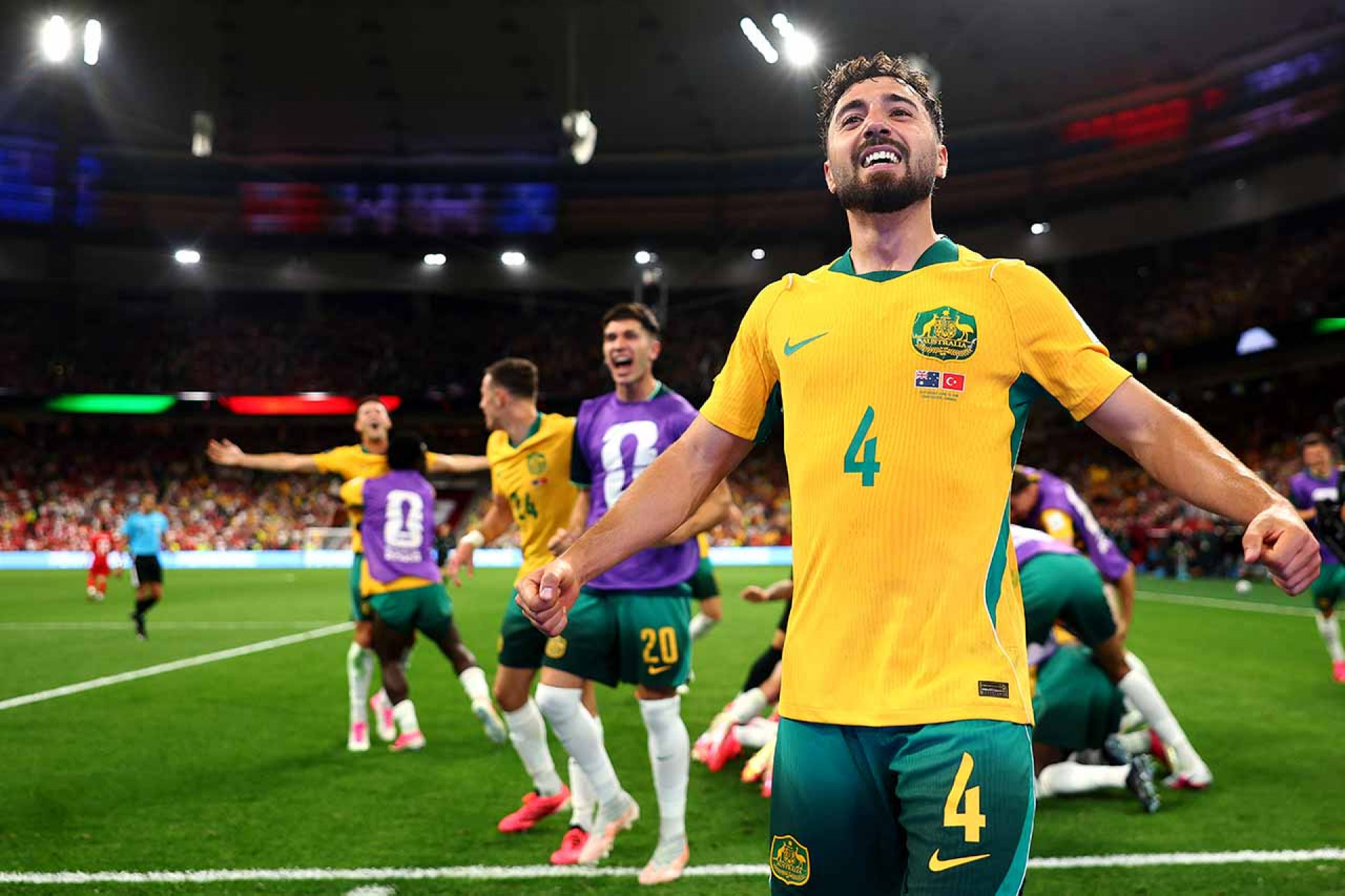 VANCOUVER, BRITISH COLUMBIA - JUNE 13: Jacob Italiano #4 of Australia leads as Connor Metcalfe #8 of Australia celebrates scoring his team's second goal with teammates jumping on top of him during the FIFA World Cup 2026 Group D match between Australia and T&uuml;rkiye at BC Place Vancouver on June 13, 2026 in Vancouver, British Columbia. (Photo by Dean Mouhtaropoulos/Getty Images)