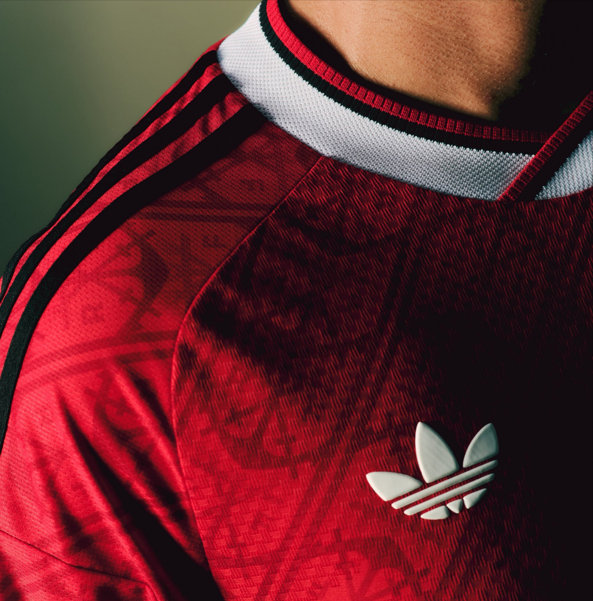 Uniforme tem três listras pretas na manga, traço característico da Adidas, e gola branca - Divulgação / Adidas