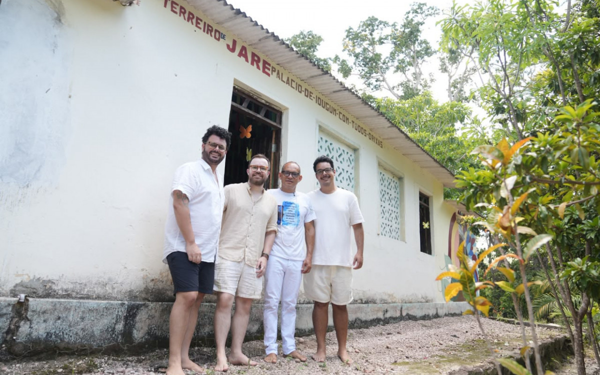 Gabriel Haddad, Leonardo Bora e Vinicius Natal (à direita) posam em frente ao terreiro de Jaré