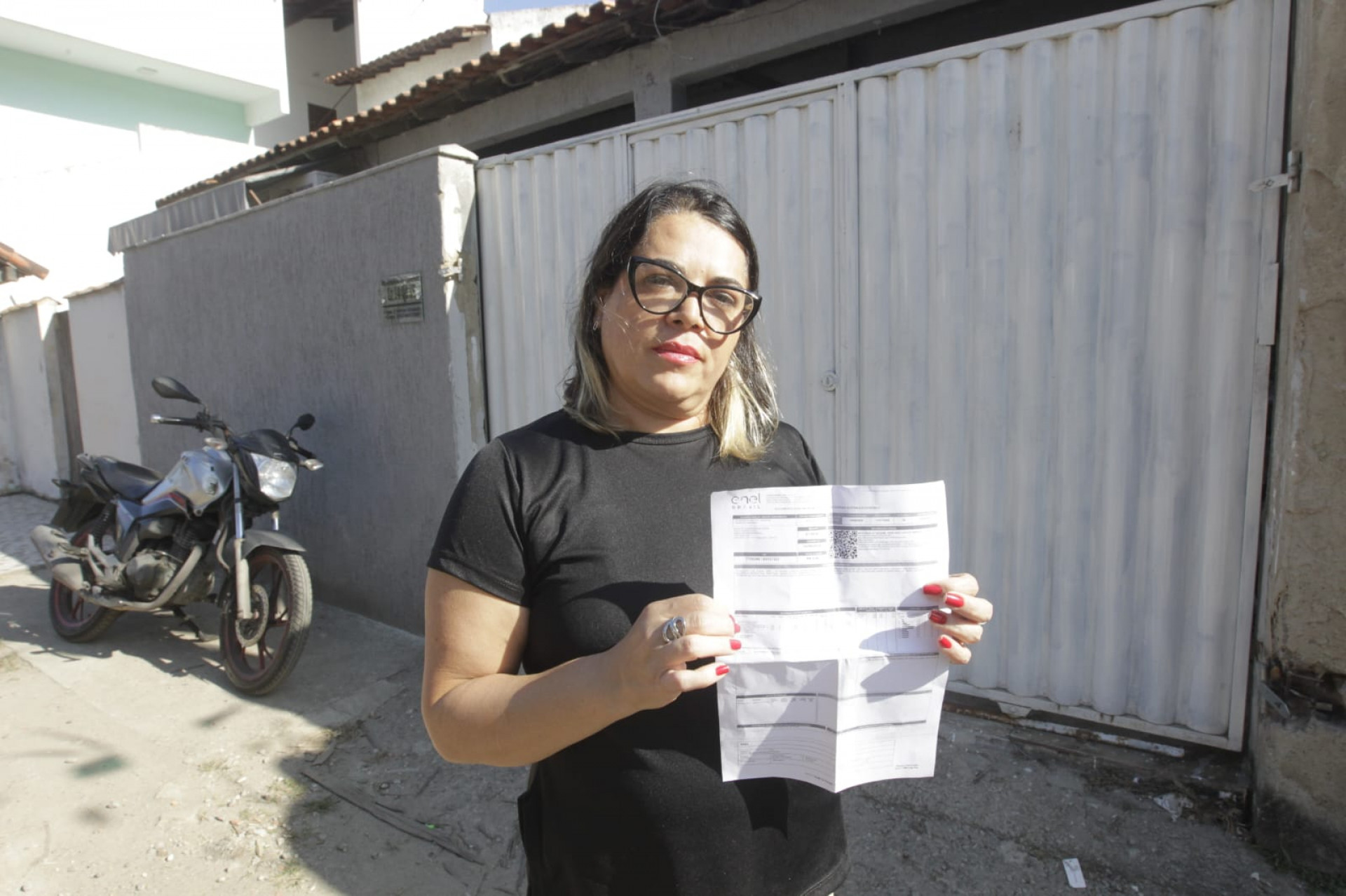 Com a conta de luz em mãos, Claudia Botelho, moradora de Itaipu, denúncia a Enel pelo serviço prestado - Reginaldo Pimenta / Agência O Dia