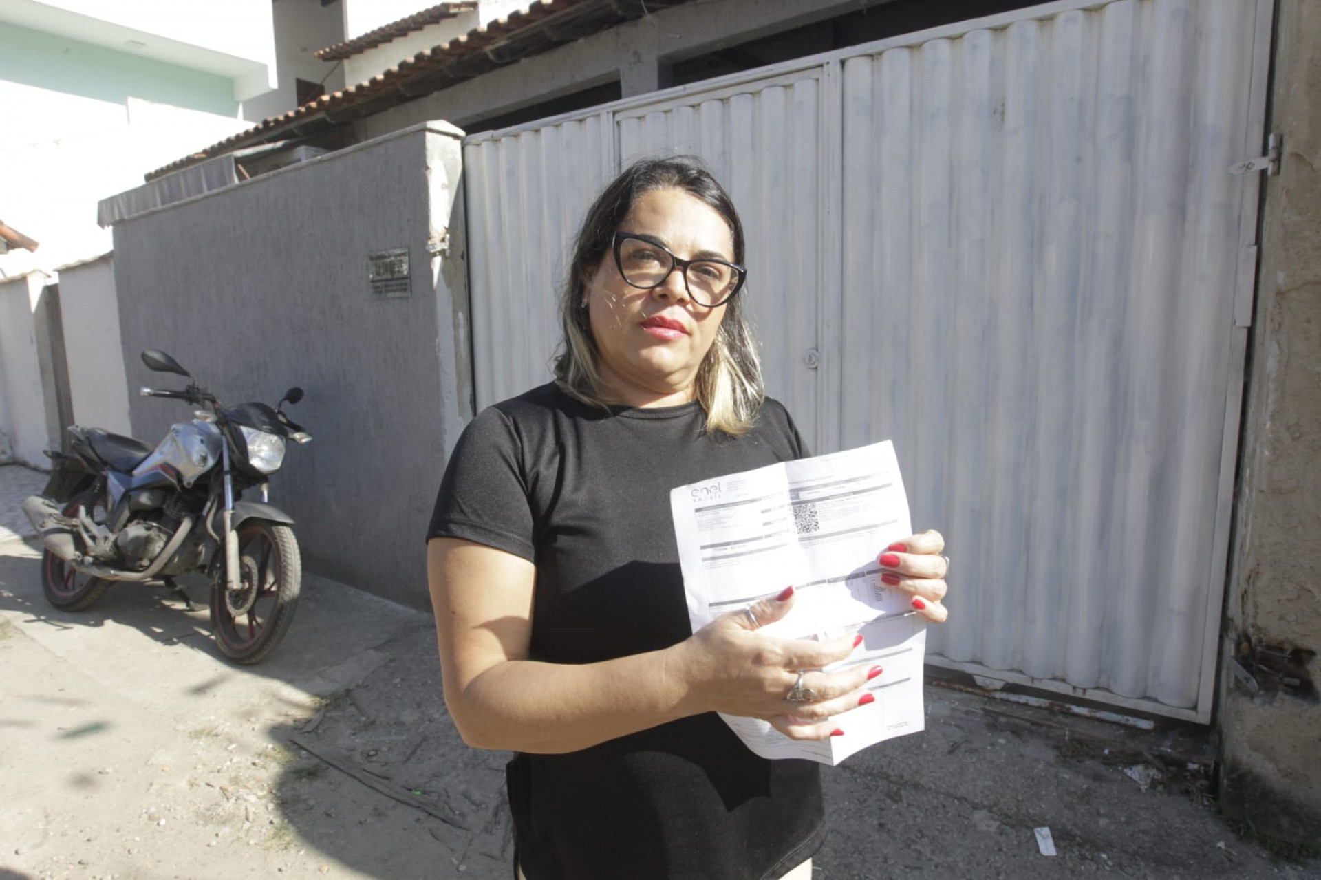 Com a conta de luz em mãos, Claudia Botelho, moradora de Itaipu, denúncia a Enel pelo serviço prestado - Reginaldo Pimenta / Agência O Dia