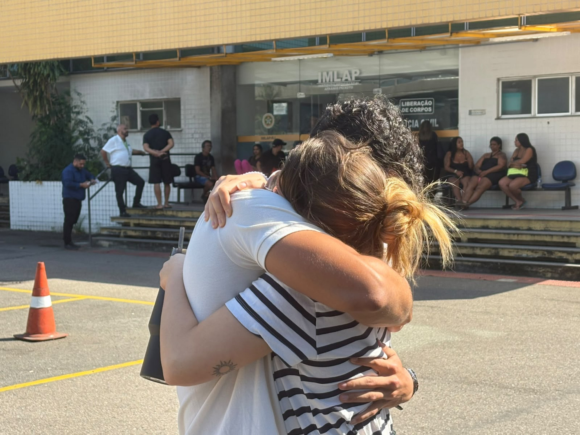 Sven Rocha, filho do piloto que morreu em queda de helicóptero, é amparado pela companheira - Fred Vidal / Agência O Dia