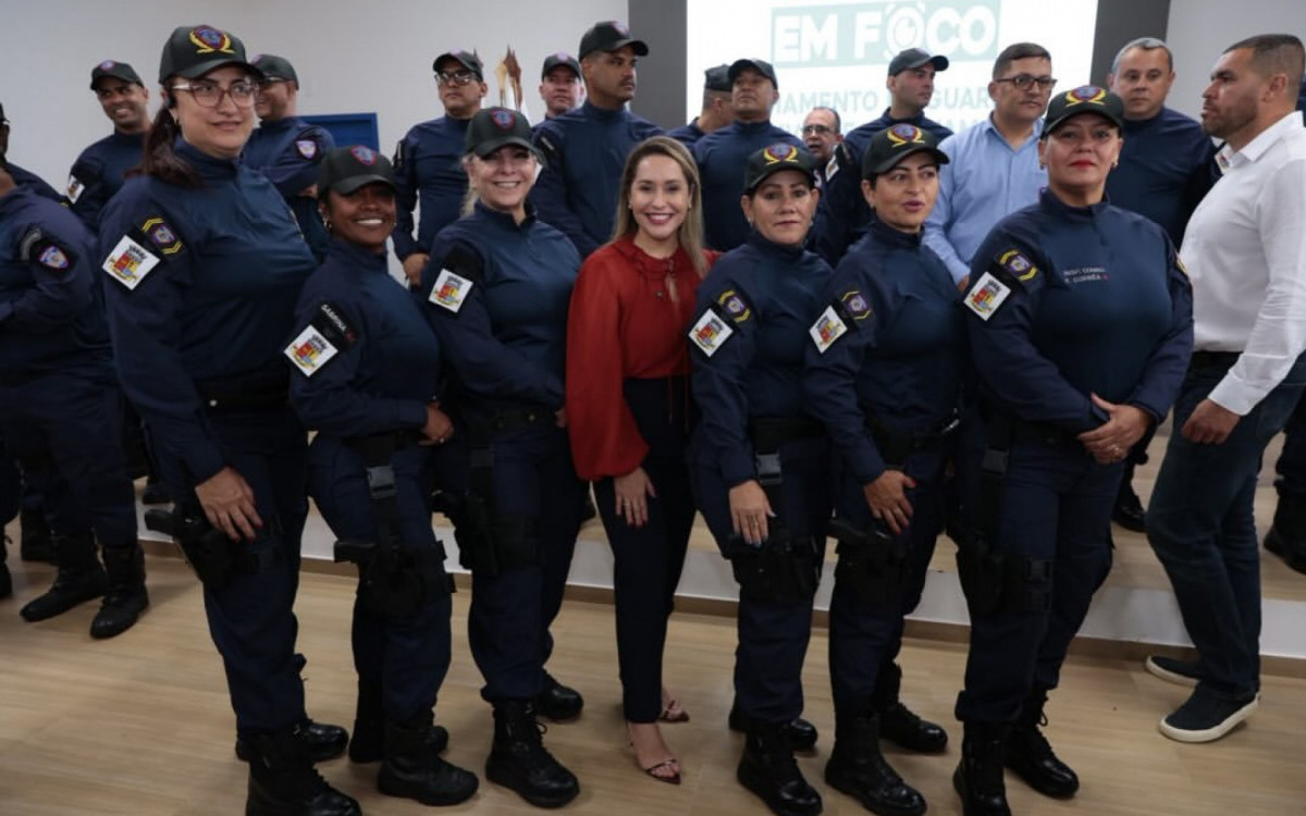 Daniela entre agentes na entrega de armamento da Guarda Civil Municipal 