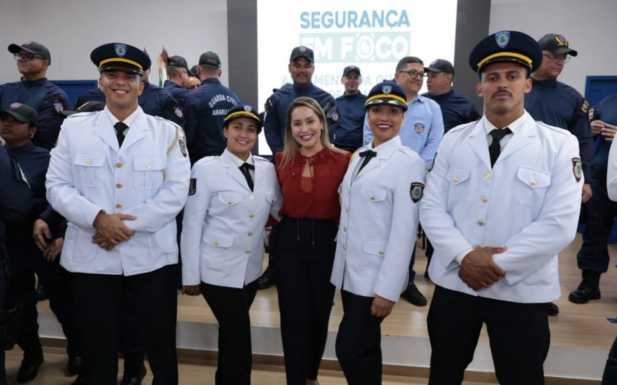 Daniela entre militares na entrega de armamento da Guarda Civil Municipal 