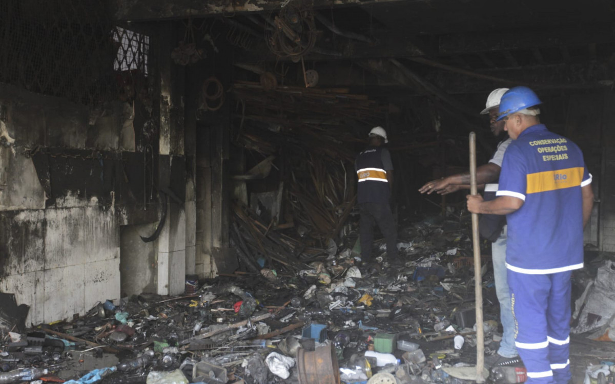 Em meios aos escombros, equipes realizam limpeza de edifício que pegou fogo
