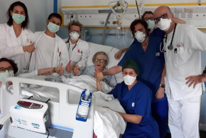 Italiana Alma Clara Corsini, de 95 anos, com equipe médica de hospital em Modena