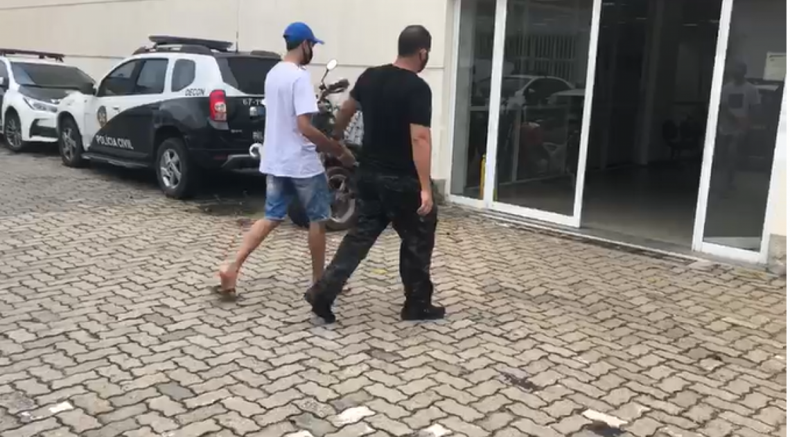 Ex-foragido da justiça sendo conduzido por agente do DRFA após sua prisão - Reprodução/DRFA