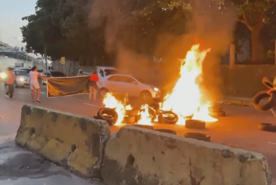 Manifestantes colocam fogo em pneus na Avenida Brasil, altura do Into