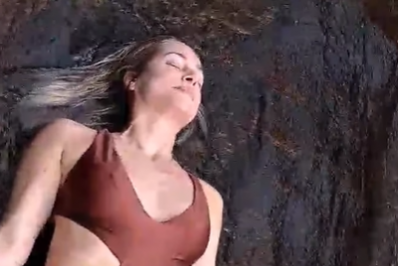 De maiô decotado, Leticia Spiller relaxa e medita durante banho de cachoeira