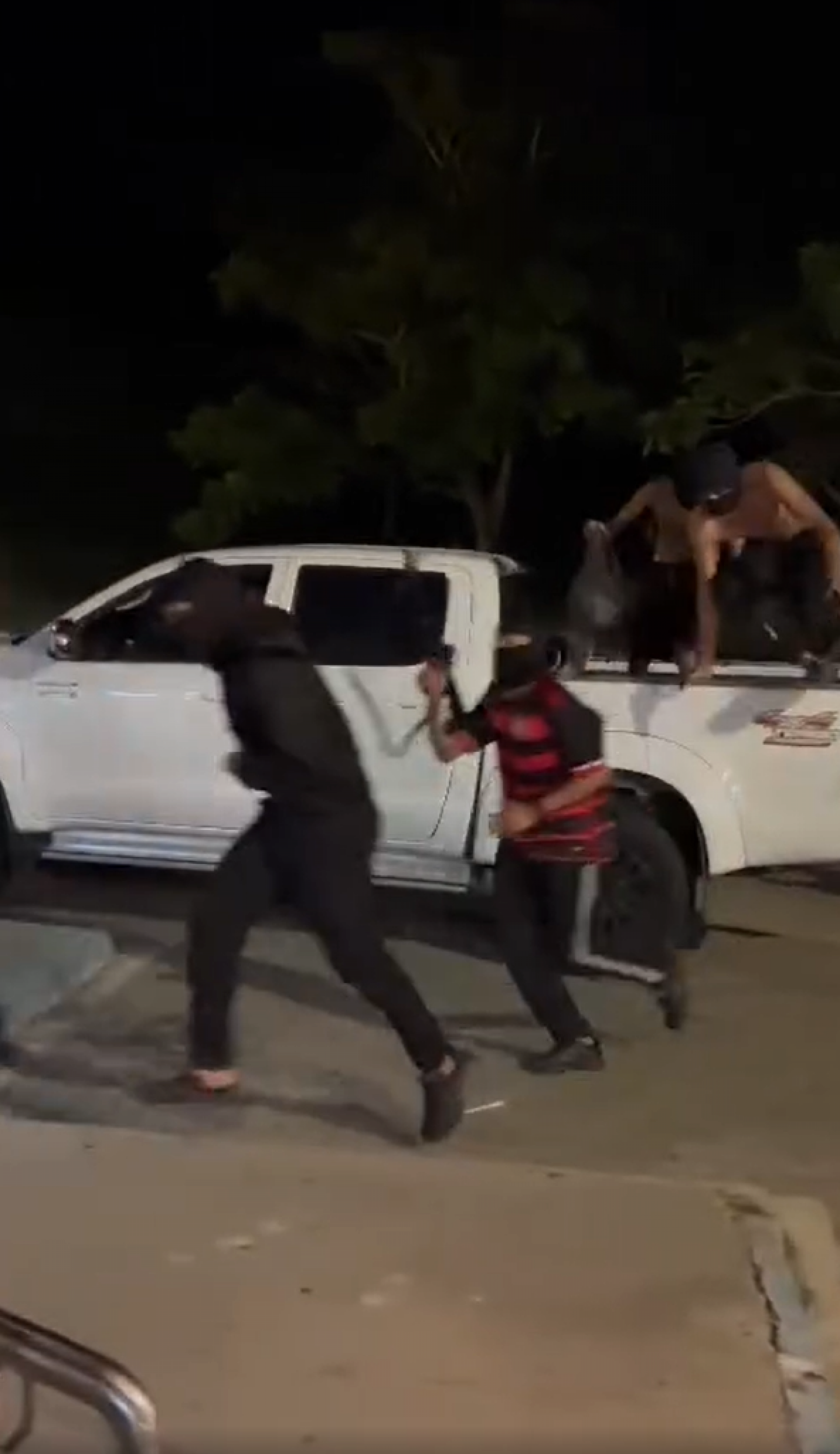 Na grava&ccedil;&atilde;o, eles des&ccedil;eram da ca&ccedil;amba de um carro, carregando r&eacute;plicas de fuzil