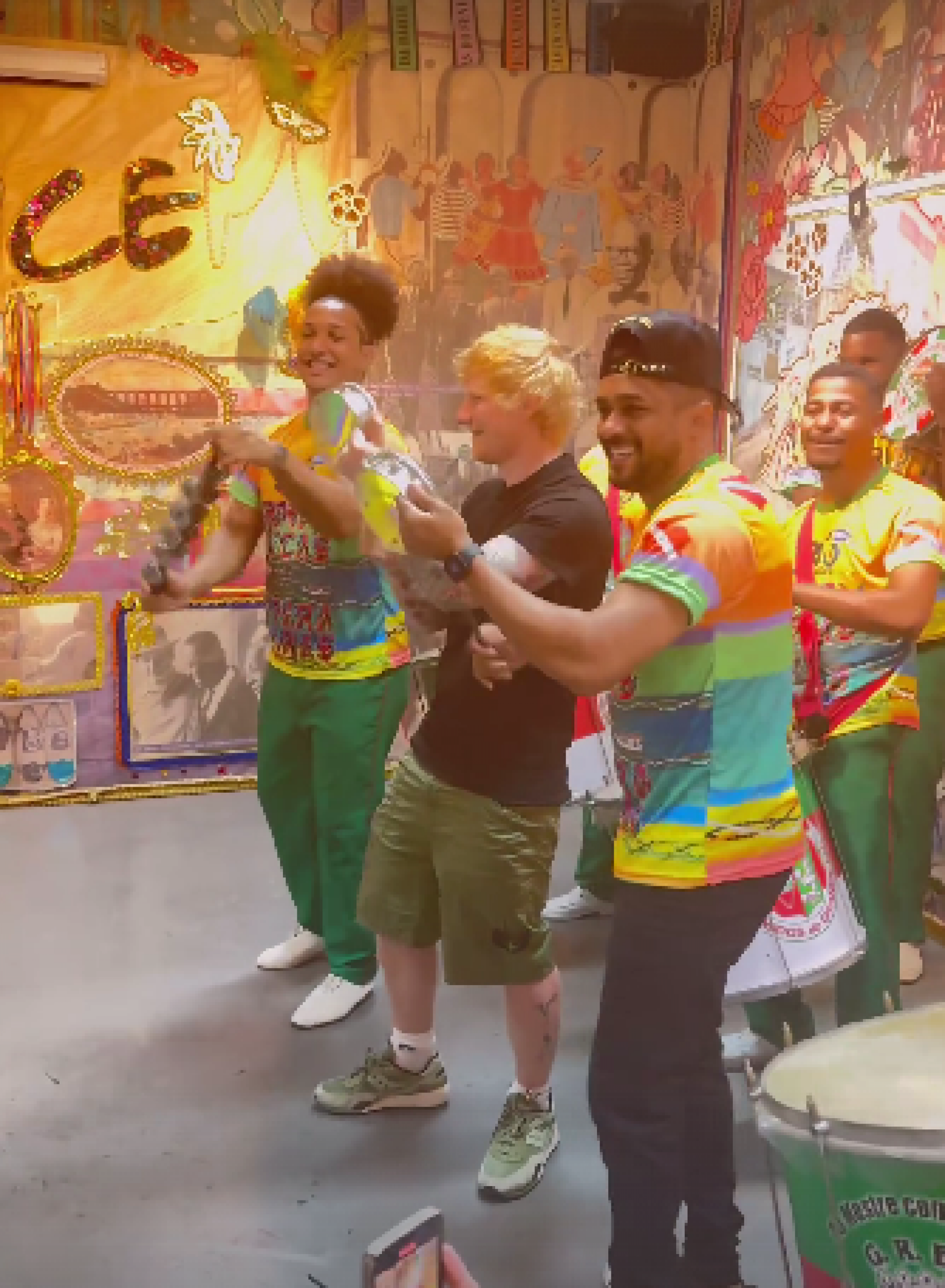 Ed Sheraan tocando tamborim com a bateria da Grande Rio