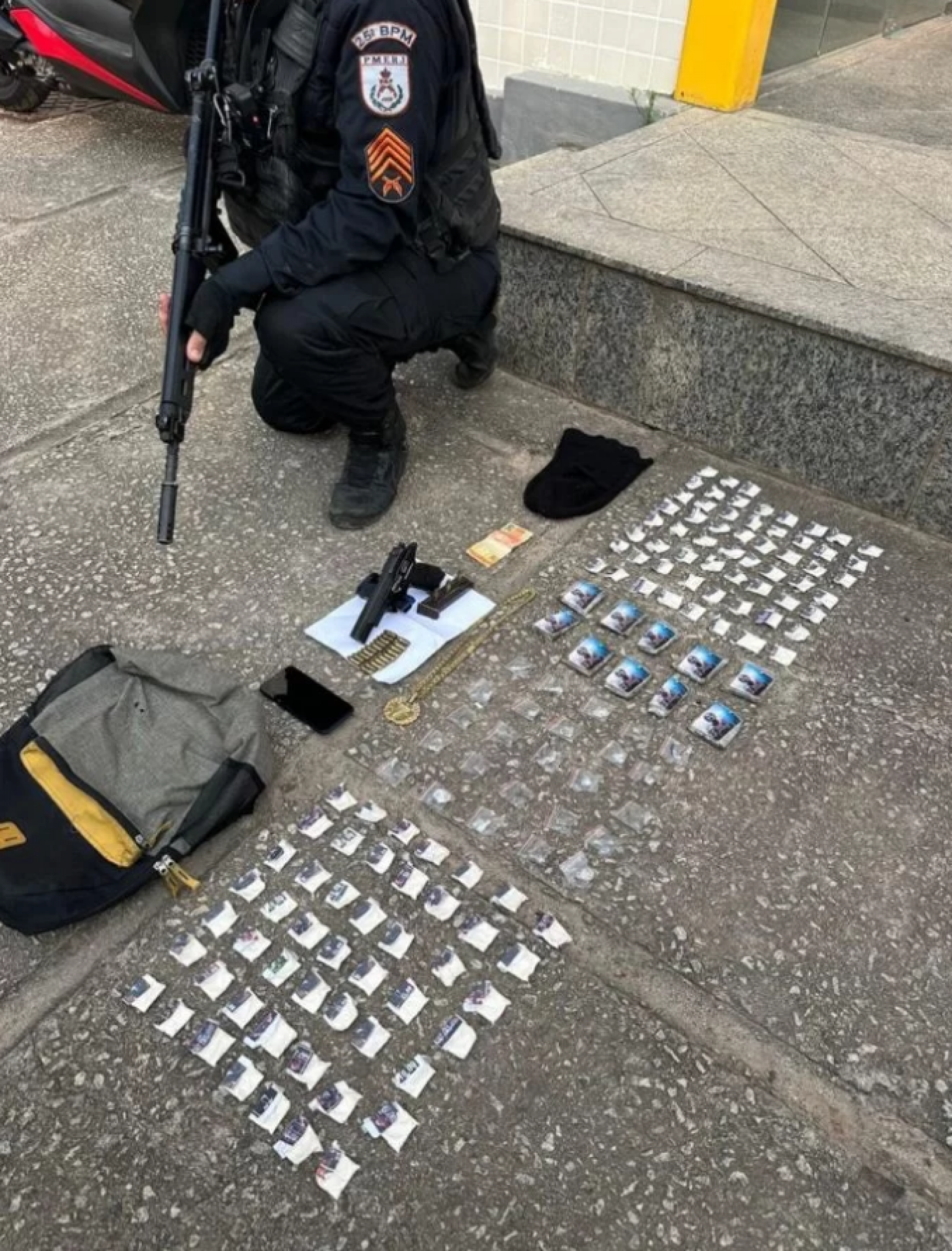 Uma pistola 9mm Beretta, dois carregadores, 23 munições, um telefone celular, 110 cápsulas, 10 buchas de maconha, 25 porções de Skank e R$ 20 em espécie